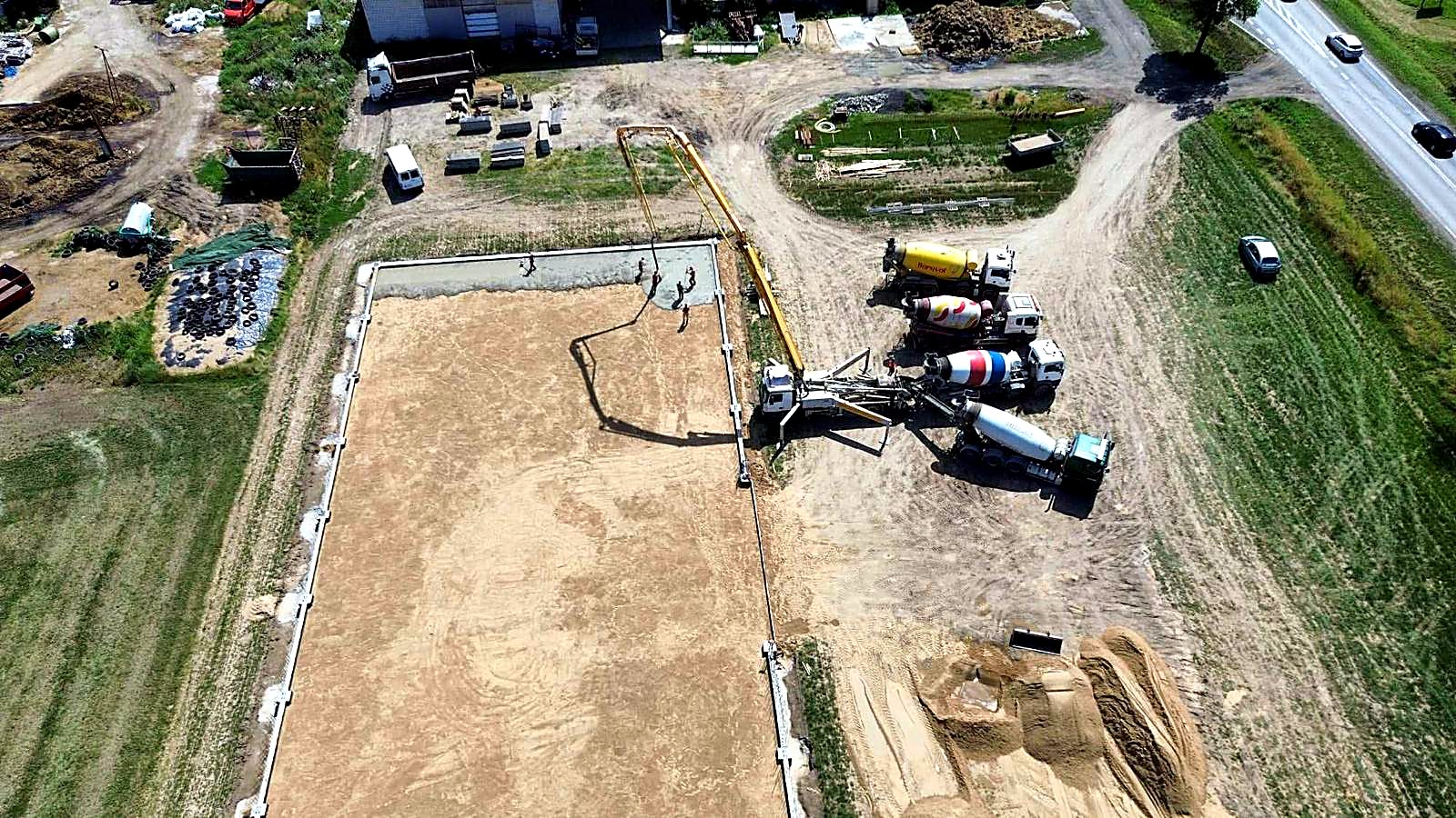 Wylewanie betonu na płycie fundamentowej widziane z drona