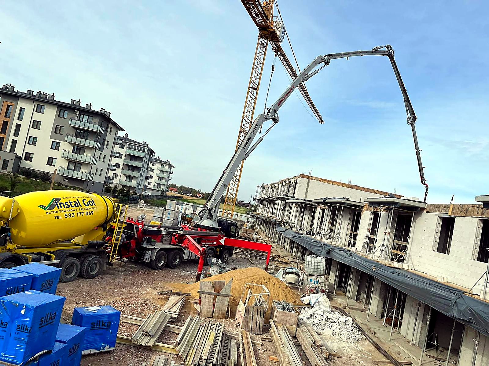 Betonomieszarka INSTAL-GOŁ i pompa z rozłożonym masztem na budowie budynków wielorodzinnych
