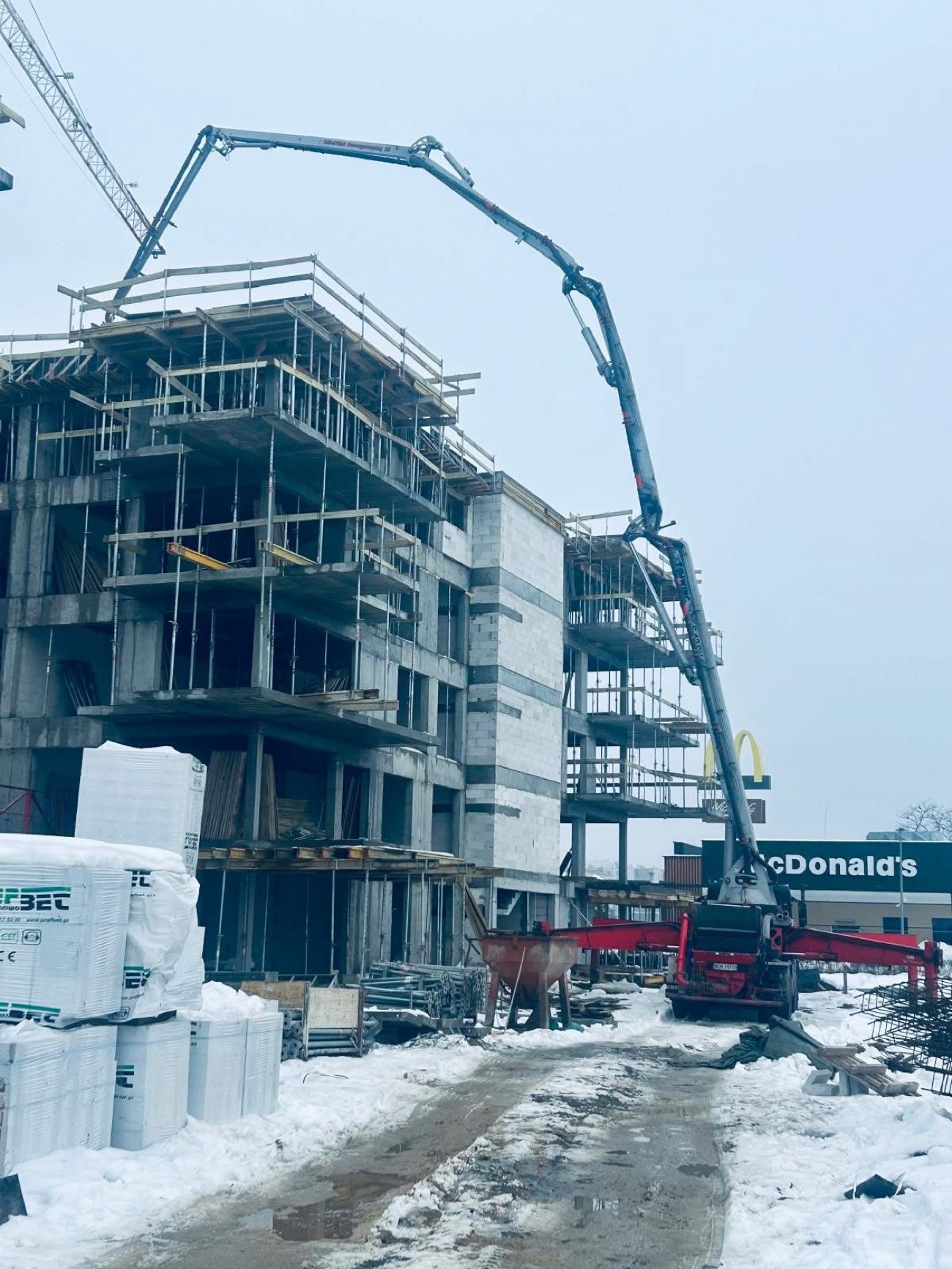 Budynek wielorodzinny w trakcie betonowania stropu zimą