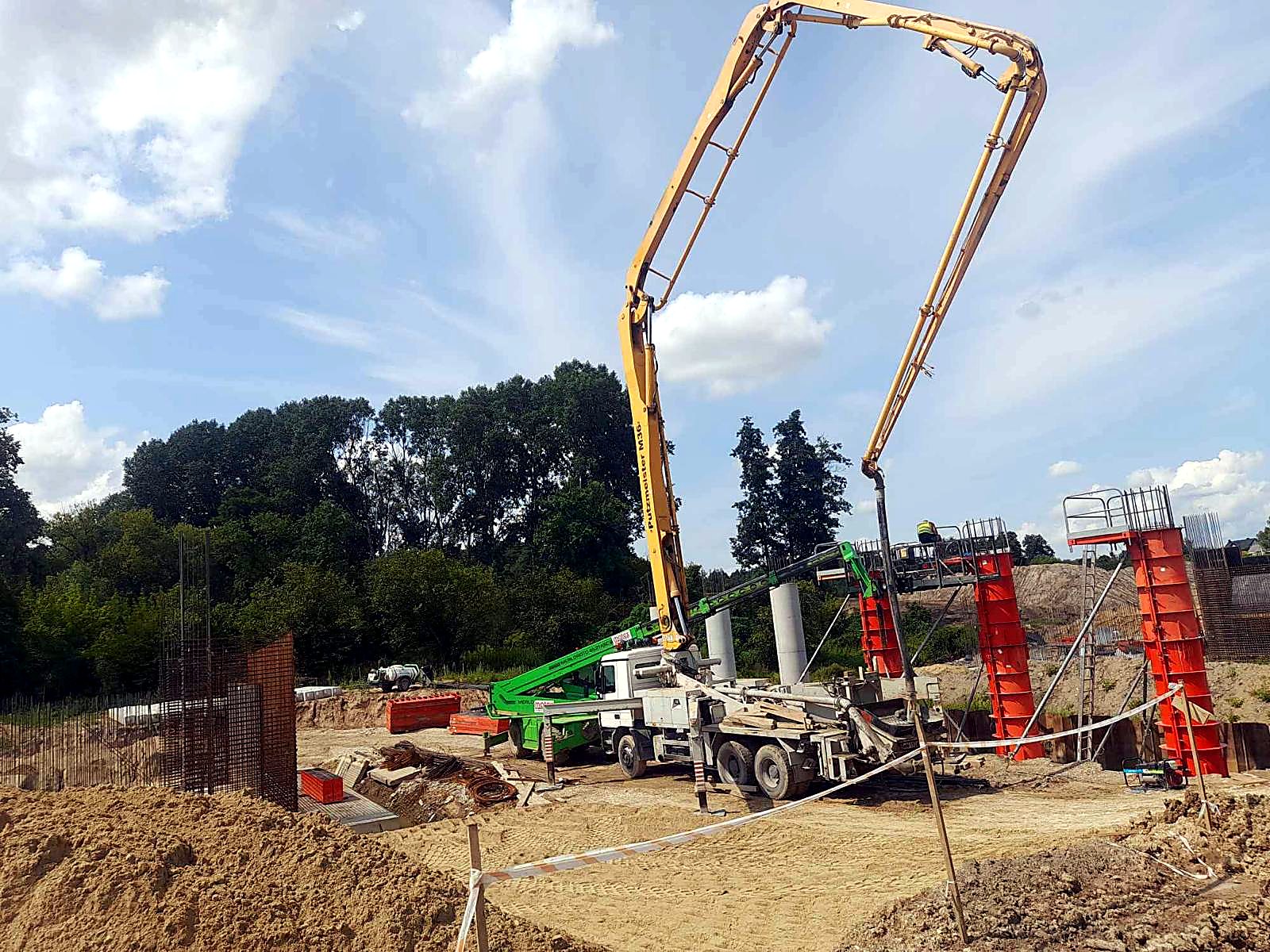 Pompa z rozłożonym wysięgnikiem podczas betonowania słupów w szalunkach
