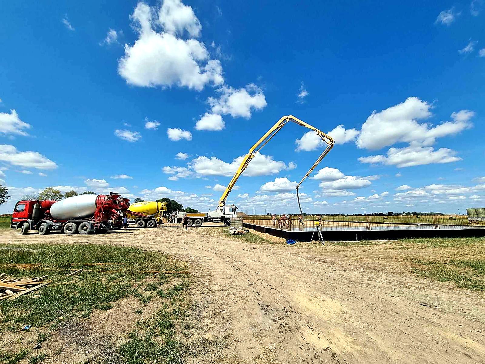 Pompa do betonu z rozłożonym wysięgnikiem nad zbrojoną płytą fundamentową