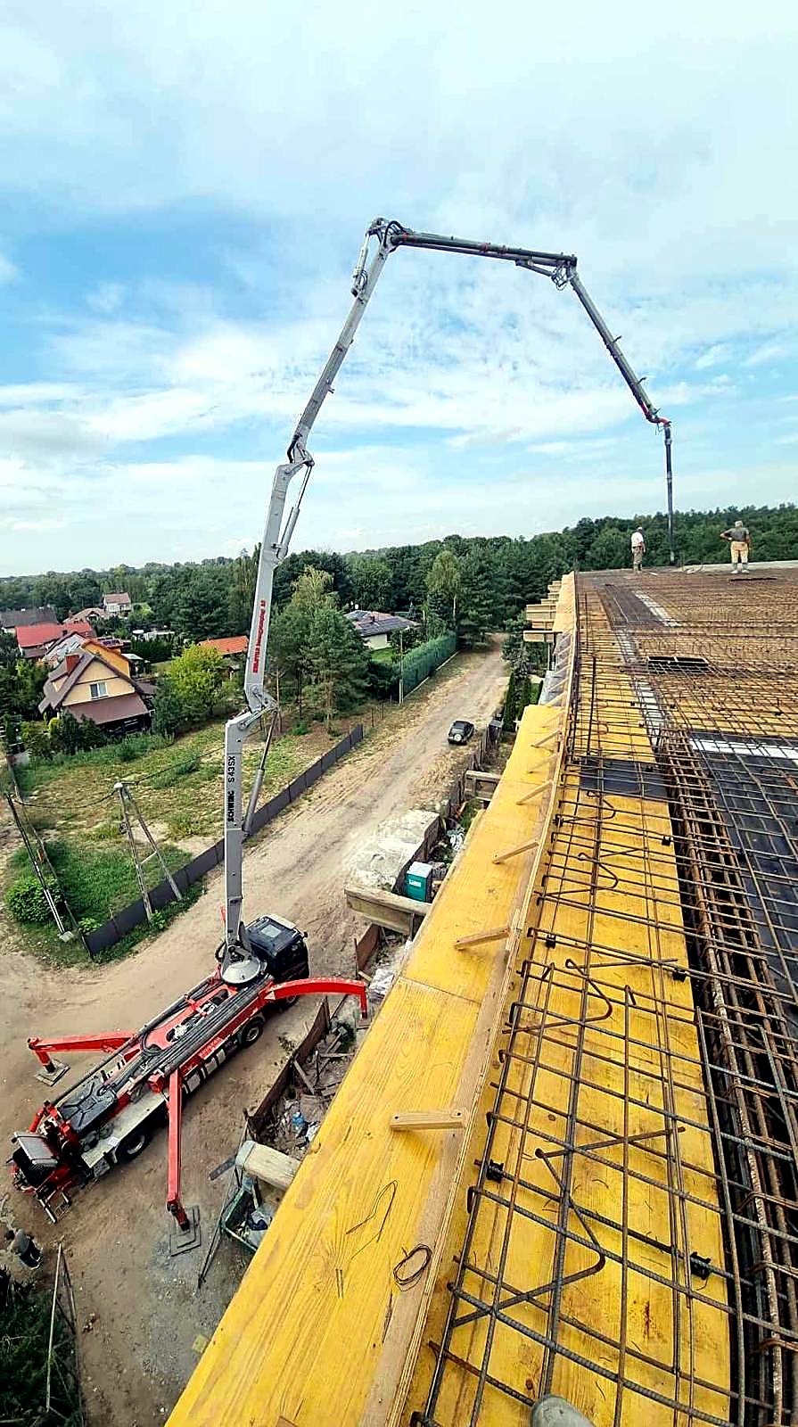 Wysięgnik pompy nad zazbrojoną płytą stropu, widok z deskowania